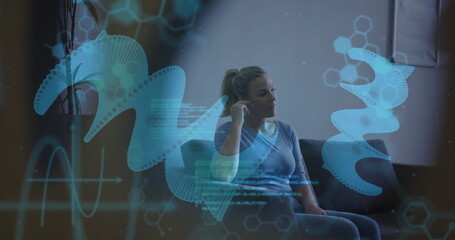 Poster - Image of dna strands with data processing over caucasian woman sitting on sofa