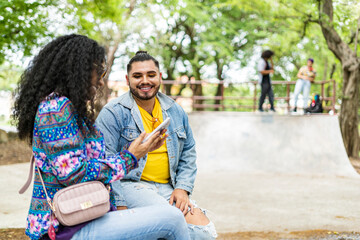 Two lgbtq friends in the park with the phone