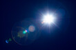 © Mr. Music - Bright sunlight shining in dark blue sky with lens flares.