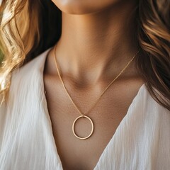 Closeup of a woman wearing a delicate gold chain necklace with a circle pendant.