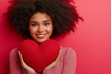 Wall Mural - A woman is holding a red heart in her hand and smiling. Concept of love and happiness