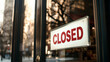 © dvoevnore - Closed sign on the glass door of a shop with urban cityscape background