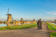 © Noppasinw - Dutch Windmill landscape at Kinderdijk Village Netherlands with love couple walking