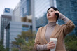 © zhouyilu - Modern Woman Enjoying Coffee in Urban Landscape