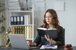 © amnaj - Lawyer working on laptop and reading law book in office