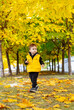 © Vadim - Child walks a colorful autumn path of yellow trees. A young child enjoys a stroll along a path covered with golden leaves in autumn.
