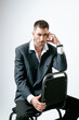 © Elina Leonova - Handsome man, fashion model sits on chair