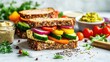 © วรรณภา มะโนศรี - A healthy sandwich with whole-grain bread, hummus, and fresh vegetables, arranged on a white surface with a focus on the vibrant colors and textures.