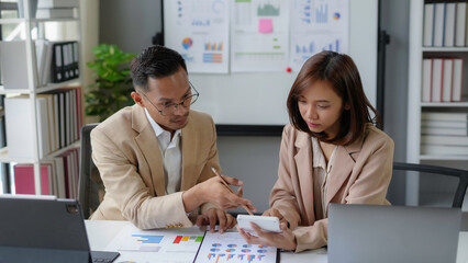 Wall Mural - Business people analyzing financial data using calculator and laptop in office