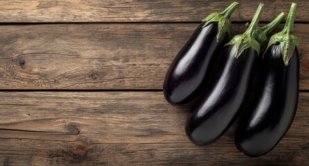 Wall Mural - Freshly harvested eggplants resting on a rustic wooden table in natural light