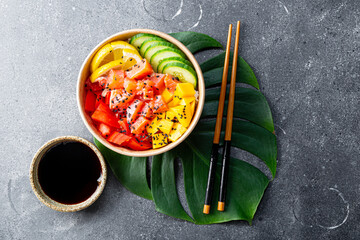 Poke bowl with salmon, mango and vegetables top view copy space for text