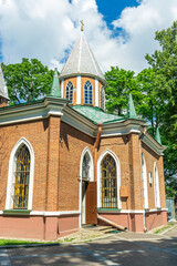 A brick building with a steeple and a cross on top