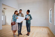 © Drazen - Happy couple examining housing plans with their real estate agent while buying new home.