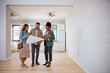 © Drazen - Couple of real estate buyers and their agent examining housing plans.