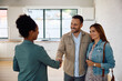 © Drazen - Happy man shaking hands with real estate agent while buy new home with his wife.