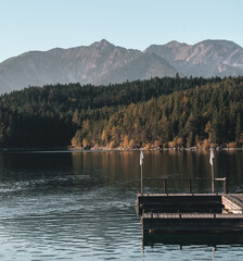 Jetty at Lake Eibsee in Bavaria, southern Germany. The surrounding forest and mountains of the Alps are visible in the background.