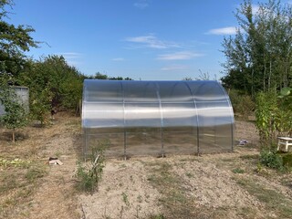 Installation of a metal frame greenhouse with polycarbonate covering