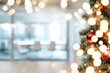 © Victoria - Close-up of a christmas tree decorated with red baubles and fairy lights, creating a festive atmosphere in a blurred office environment