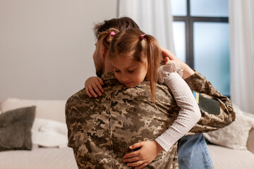 Canvas Print - military man of the Ukrainian army in camouflage uniform returned home and hugs his daughter, soldier goes to war and says goodbye to his child, the concept of mobilization in Ukraine