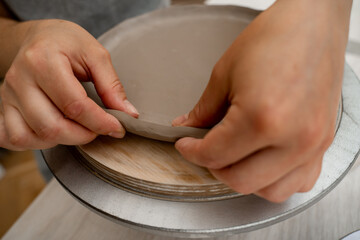 Wall Mural - Building sides for clay products. Slab pottery. Creating ceramic products from flat sheets of clay. Using hands to model a form for a clay project.