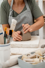 Wall Mural - Wedging the clay before starting making a pottery project to create proper consistency. Removing air bubbles from clay before modeling to avoid the ruination of a ceramic product.