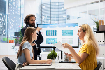 Poster - financial advisor looks at big screen, assessing clients risk tolerance to decide if their portfolio