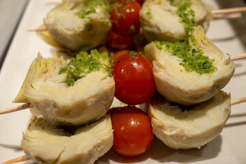 Typical snacks of Basque Country, pinchos or pinxtos skewers with small pieces of bread, fish, sea food, sweet green pepper served in bar in San-Sebastian or Bilbao, Spain