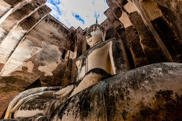 Wall Mural - The background of one of the important tourist attractions in Sukhothai Historical Park, Wat Si Chum, has a large Buddha statue that is hundreds of years old for tourists to learn about its history.