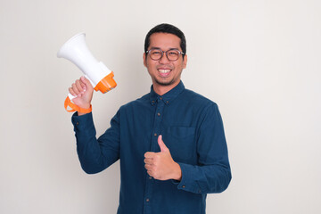 Wall Mural - A man smiling and give thumbs up while holding megaphone