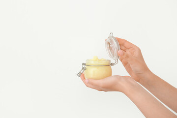 Wall Mural - Female hands with jar of lemon body scrub on white background