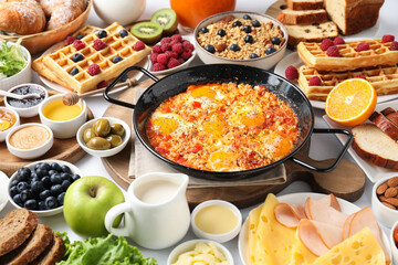 Different meals served for breakfast on white table