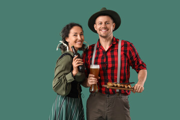 Wall Mural - Happy mature waiters in traditional German clothes with glass, bottle of beer and sausages on green background