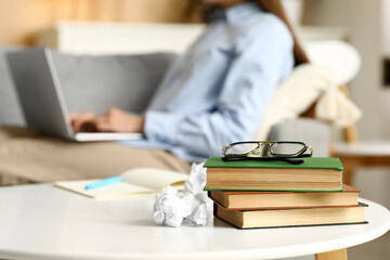 Wall Mural - Beautiful female writer with laptop, notebook and books on  table, closeup