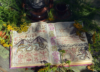 Wall Mural - Mystic still life with magic book of spells, old lantern and healing herbs on old table. Occult, esoteric, wicca and divination concept. No foreign language, all symbols are fictional