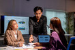 © Wasana - Asian business team working late and brainstorming using data analytics on screen