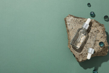 Wall Mural - Cosmetic oil in a transparent bottle with a stone