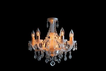 An ornate crystal chandelier with lit bulbs illuminating against a dark black background, showcasing elegance and luxury.