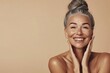 © Kateryna - Portrait of a joyful mature woman with gray hair and a radiant smile, showcasing natural beauty and confidence against a beige background. Generated AI