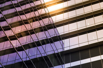 reflective glass windows of a modern geometric building in sunlight