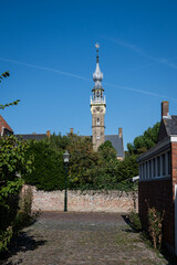 Town Hall of Veere stadhuis in Dutch. impressive gothic building landmark in popular historic zeeland destination houses museum with quiet street road in foreground on sunny blue sky summer day 