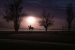 © Cavan Images - Horse and rider silhouetted against a foggy glowing purple sky