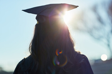 Canvas Print - Success, university and silhouette of student with graduation cap for award ceremony, achievement and education. Opportunity, campus and woman thinking at college event with lens flare from back