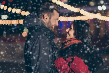 Poster - Photo of two sweethearts pair in love attending city park at newyear midnight standing opposite wearing warm winter jackets outdoors