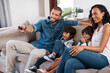 © Chanelle2000/peopleimages.com - Happy, TV and parents with kids on sofa in home for bonding, relax and watching movies in living room. Remote, family and mom, dad and children on couch streaming cartoons, entertainment and series