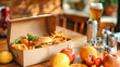 © Anoo - A cardboard box filled with burgers and fries sits on a rustic table, surrounded by fresh fruits and beer cans, creating a vibrant feast