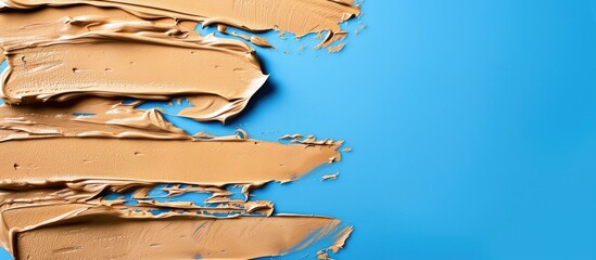 Poster - Makeup foundation smudges on a blue backdrop with copy space image