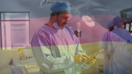 Poster - Animation of flag of germany over biracial male surgeon using tablet in hospital