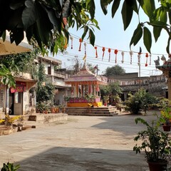 Poster - A traditional Indian temple courtyard with colorful decorations and lush greenery.