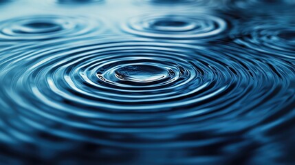 Poster - A close-up shot of water ripples, capturing the serene beauty of droplets creating circular patterns in a tranquil blue surface.