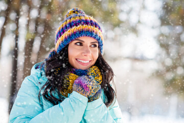 Wall Mural - Photo of positive lovely lady warming hands look side wear knitted mittens headwear scarf coat in park outdoors